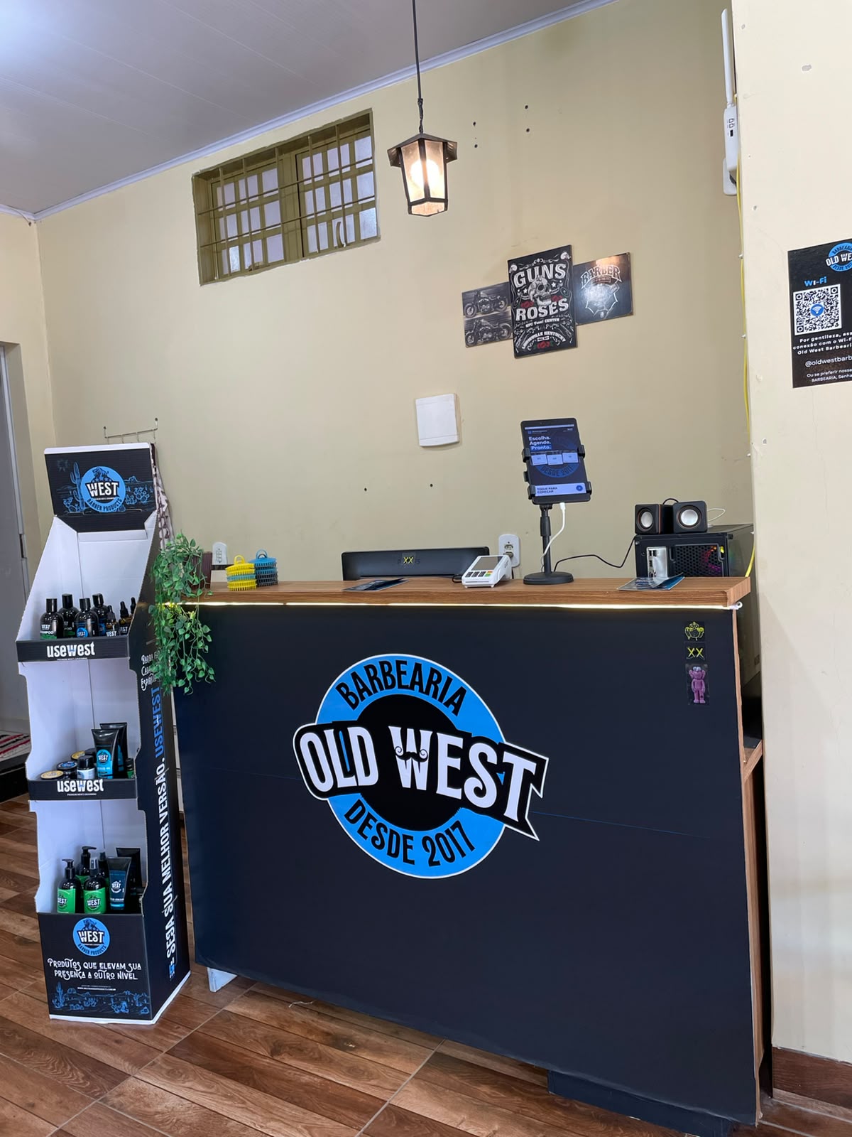 Recepção da OLD WEST Barbearia com o balcão e a linha de produtos WEST